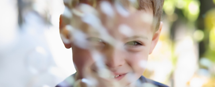 young boy smiling behind bubbles