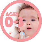 Infant with Down syndrome lying on a white blanket with red and yellow dots. Infant has a feeding tube.