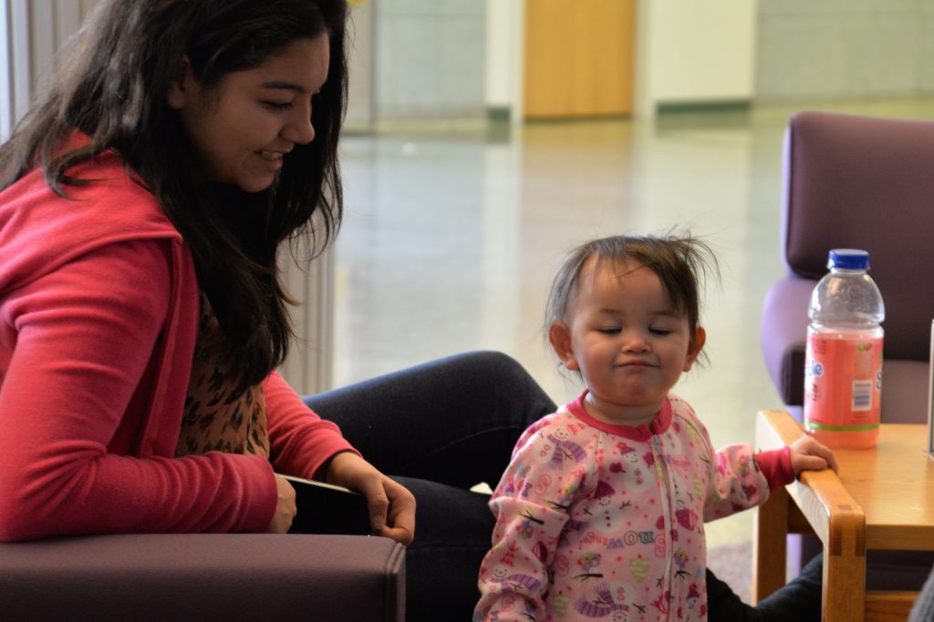 Mother smiles at toddler exploring