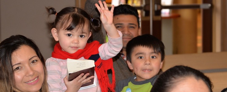 Family with small children, waving at the camera.