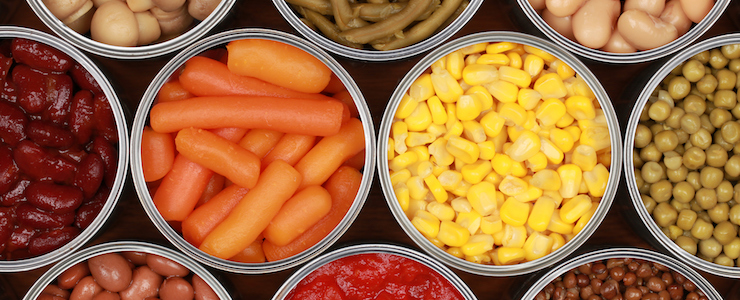 Different kinds of vegetables such as corn, peas and tomatoes in cans.