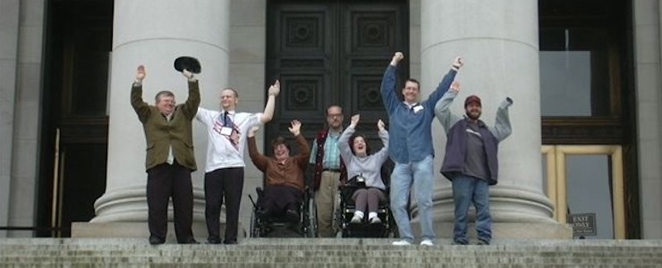 Disability advocates cheering on steps of state capitol building in Olympia, WA.
