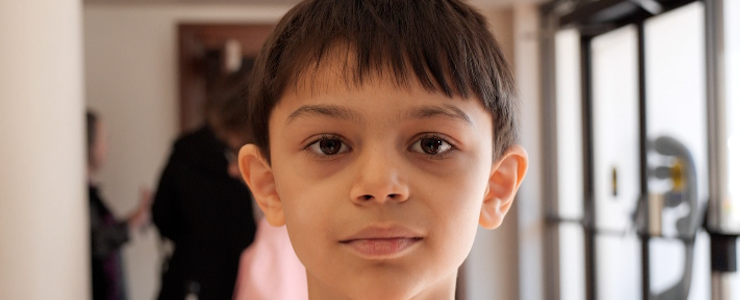 Young boy looking into camera. Blurry background.