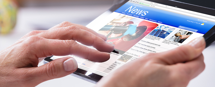 Close-up Of A Person's Hand Using Digital Tablet With Screen Showing Online News