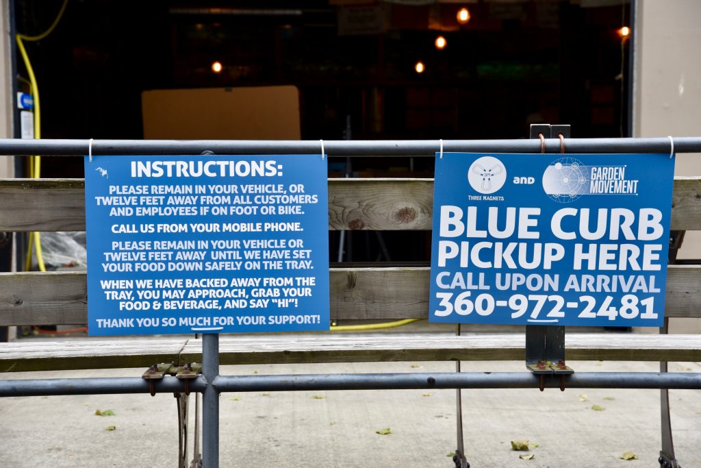 Curbside pick up signs outside a restaurant.