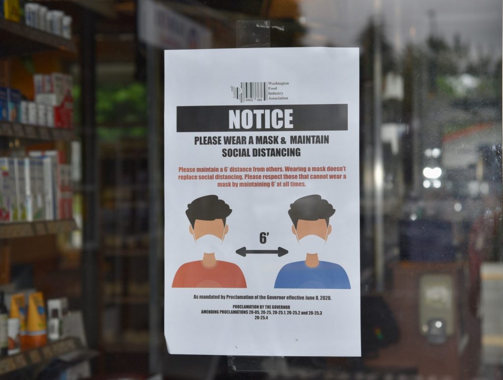 Notice of face covering ordinance in the window of a pharmacy.