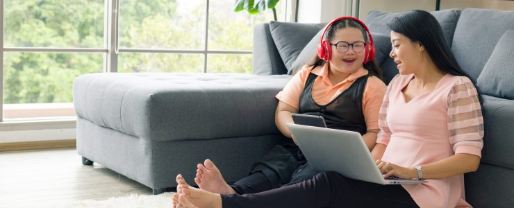 Mother and daughter at home on computer.