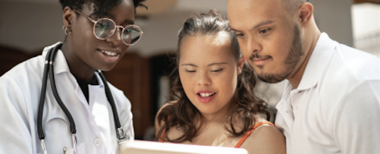 Medical provider going over information with a young disabled Latin@ couple.