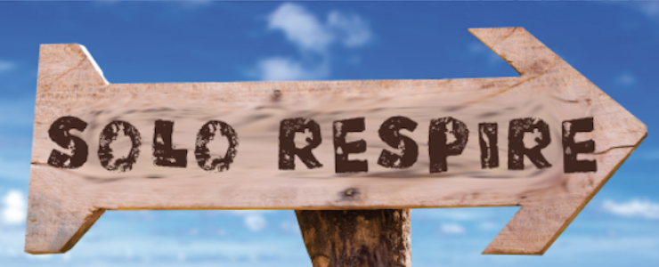 Wooden arrow sign at beach reads Solo Respire (Just Breathe)
