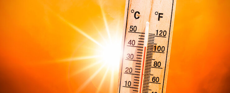 Background for a hot summer or heat wave, orange sky with with bright sun and thermometer